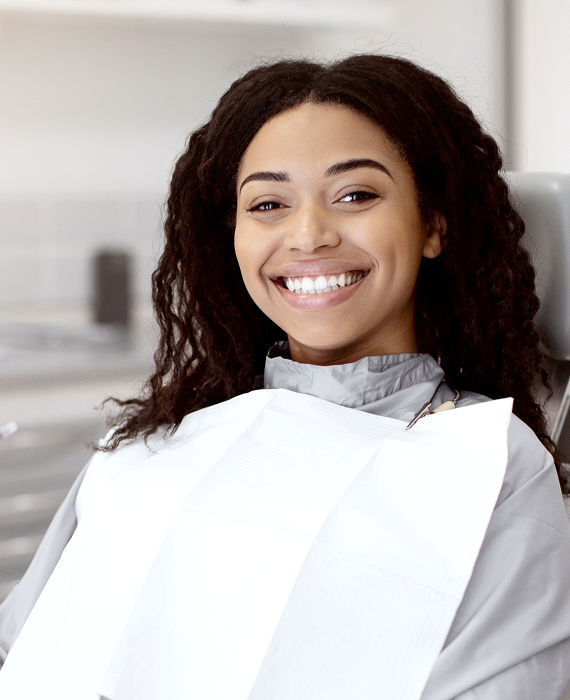 Smiling woman looking into mirror brushing her teeth smoothly
